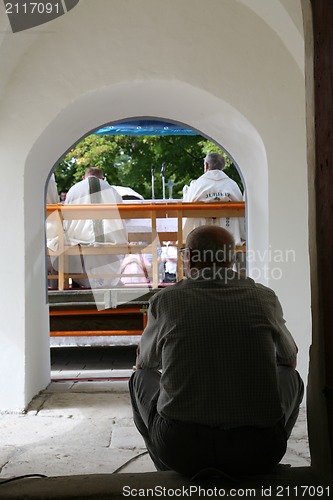 Image of Man sitting at the door of the church