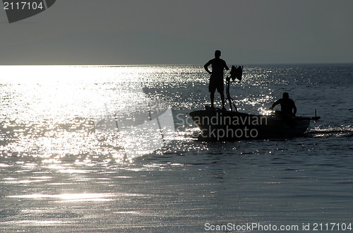 Image of Boat sailing away at sundown