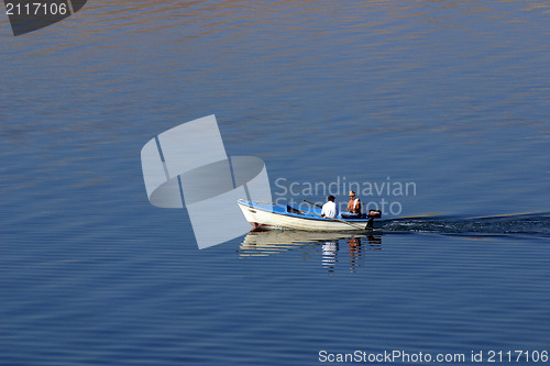 Image of Fisherman in boat sailing out