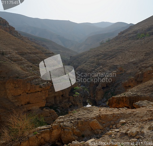 Image of Counterlight view of desert canyon with flowing creek at the bottom