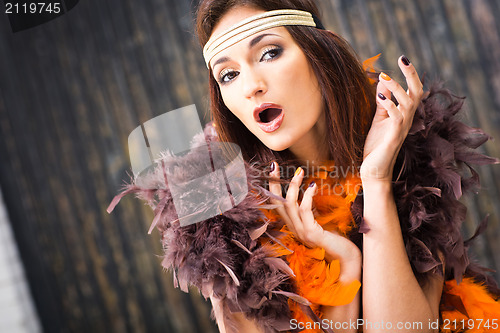 Image of singing actress in brown and orange boa