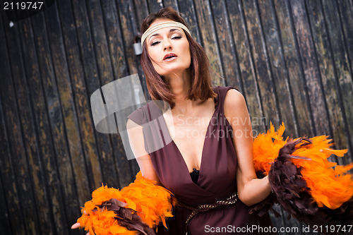 Image of singing actress in brown and orange boa