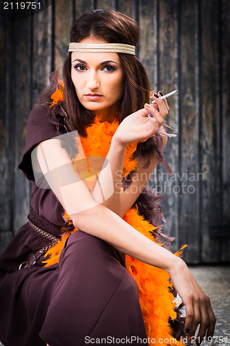 Image of smoking actress in brown and orange boa