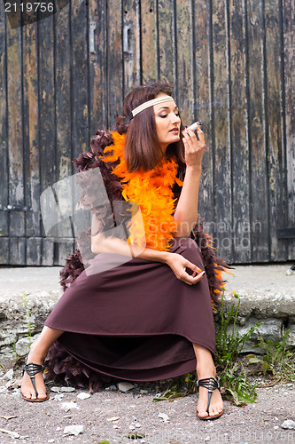 Image of smoking actress in brown and orange boa