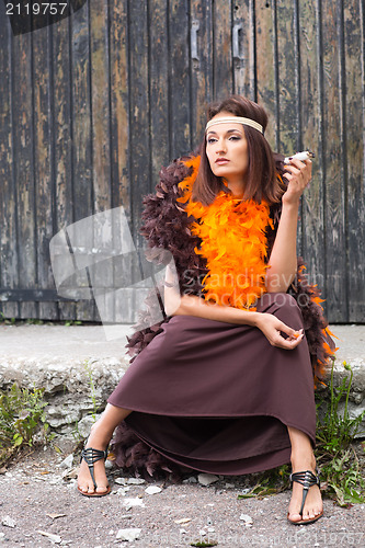 Image of smoking actress in brown and orange boa