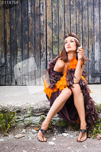 Image of smoking actress in brown and orange boa