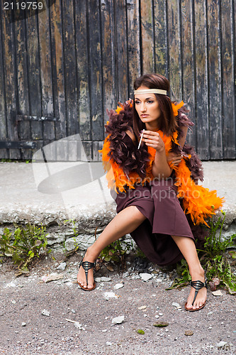 Image of smoking actress in brown and orange boa