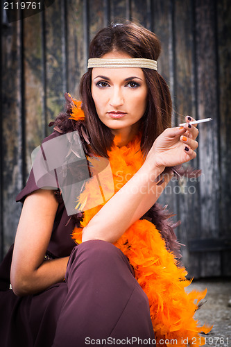 Image of smoking actress in brown and orange boa