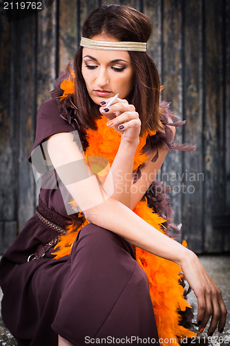 Image of smoking actress in brown and orange boa