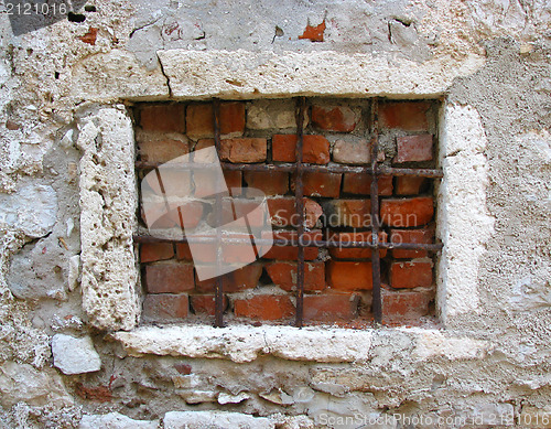 Image of Old window blocked with grates and bricks