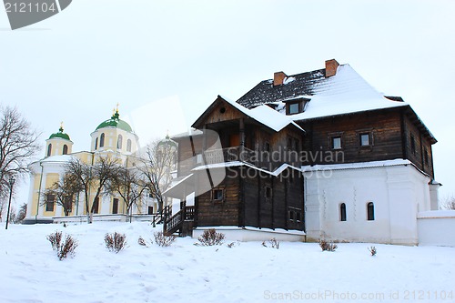 Image of the wooden house and beautiful church in winter