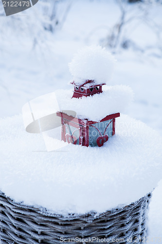 Image of Red lantern in snow filled basket