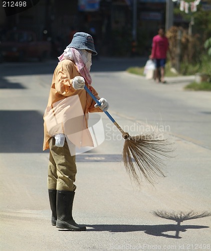 Image of Woman sweeping the street