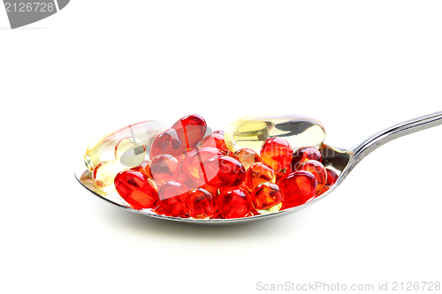 Image of Colored capsules with vitamins in a spoonful.