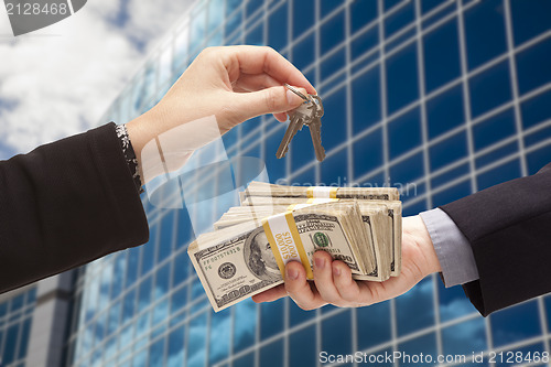 Image of Handing Stack of Cash For Key and Corporate Building