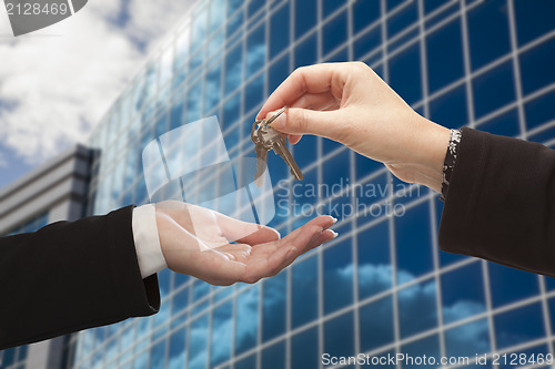 Image of Female Handing Over the Keys in Front of Corporate Building