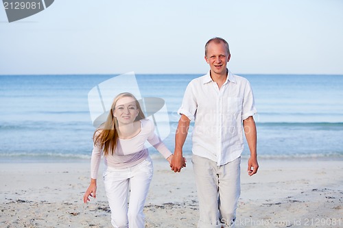 Image of happy couple in love having fun on the beach