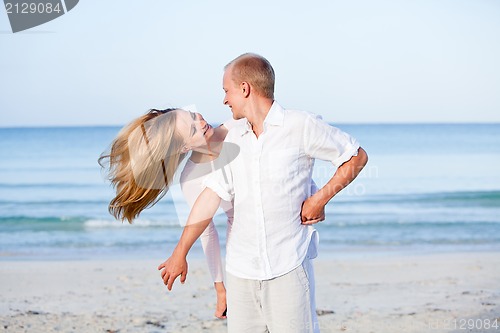 Image of happy couple in love having fun on the beach