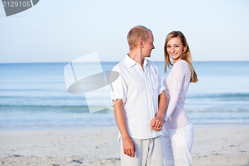 Image of happy couple in love having fun on the beach