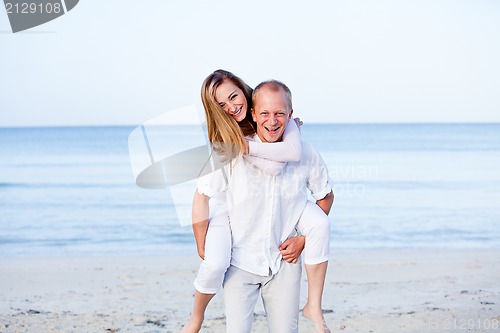 Image of happy couple in love having fun on the beach