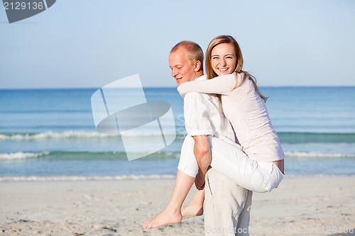 Image of happy couple in love having fun on the beach
