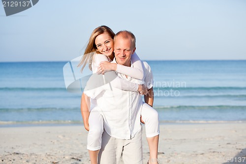 Image of happy couple in love having fun on the beach