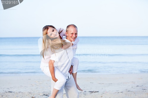 Image of happy couple in love having fun on the beach