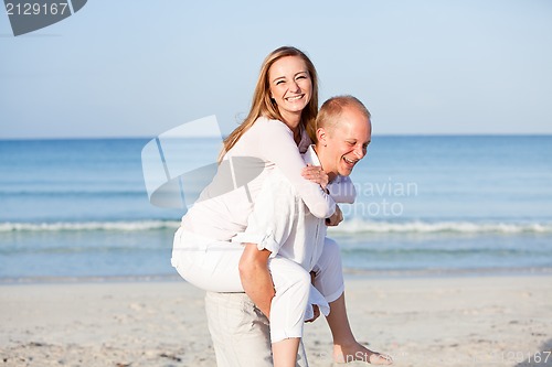 Image of happy couple in love having fun on the beach