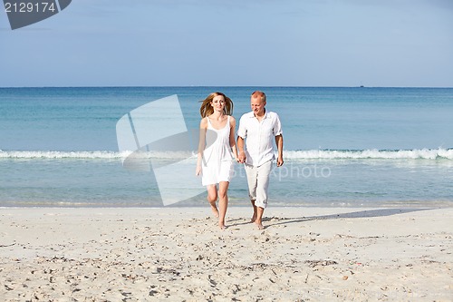 Image of happy couple in love having fun on the beach