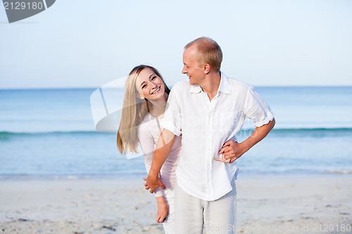 Image of happy couple in love having fun on the beach