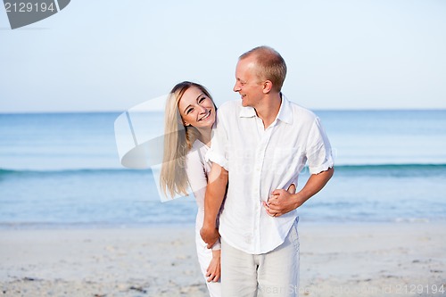 Image of happy couple in love having fun on the beach