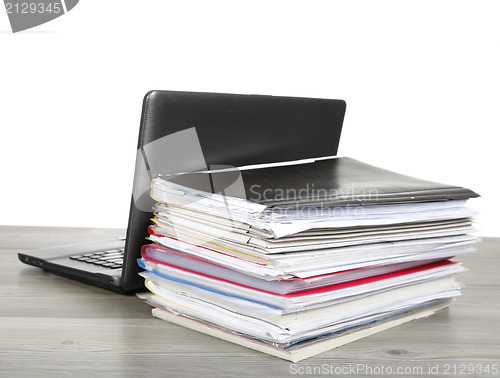 Image of Many files and a computer on a desk 