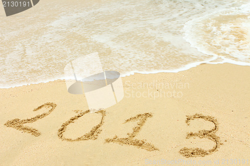 Image of 2013 written in sand on beach 