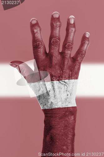 Image of Old hand with flag, European Union, Latvia