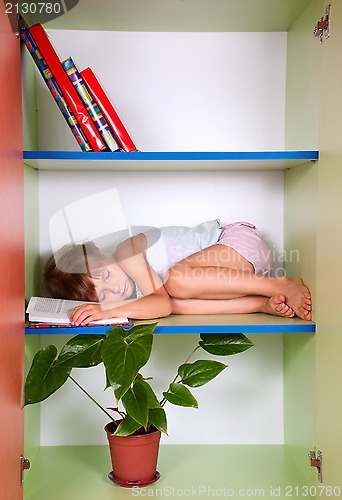 Image of tired kid sleeping on the shelf with a book instead of a pillow