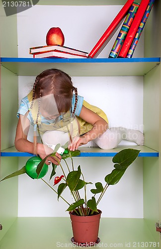 Image of kid playing and pretending the wardrobe is her home, sprinkling 