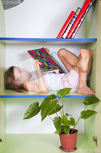 Image of child reading a book in a bookcase