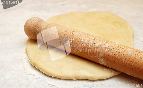 Image of Wooden rolling pin dusted with flour, ready to roll out fresh pa