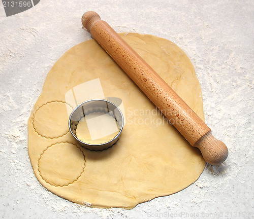 Image of Rolling pin and cutter on fresh pastry, cutting out circles 