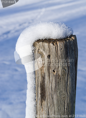 Image of snowy wooden pole