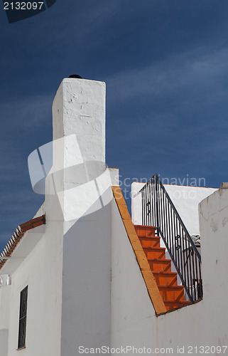 Image of Detail of white house under blue sky 