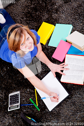 Image of happy teenager girl doing homework 