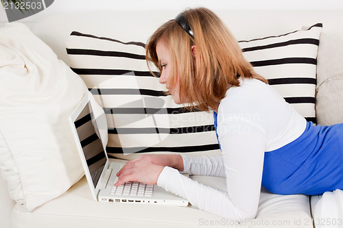 Image of young teenager girl with laptop smilig