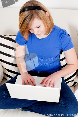 Image of young teenager girl with laptop smilig