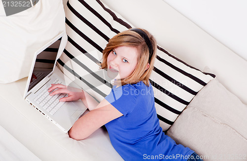 Image of young teenager girl with laptop smilig