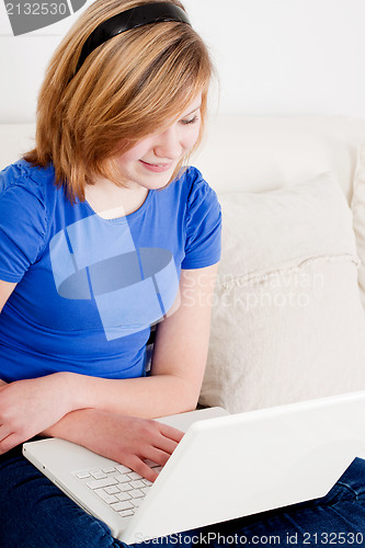 Image of young teenager girl with laptop smilig