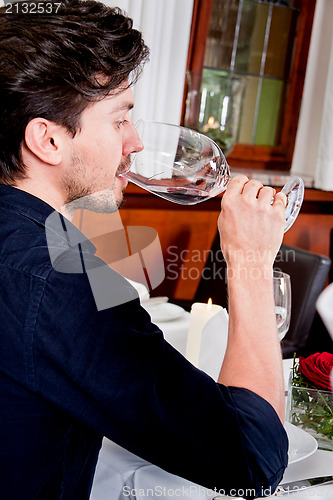 Image of couple drinking red wine in restaurant