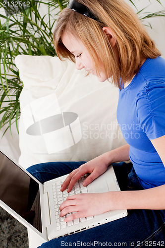 Image of young teenager girl with laptop smilig