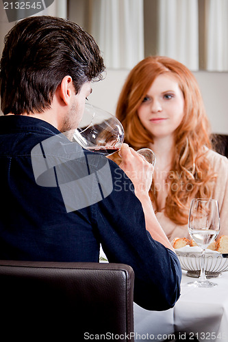 Image of couple drinking red wine in restaurant