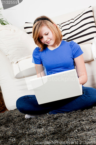 Image of young teenager girl with laptop smilig